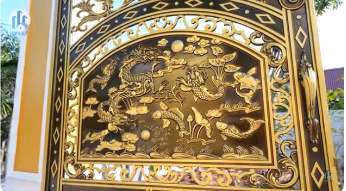 Cổng vảo biệt thự cao và rộng, trên cánh cổng có họa tiết cá chép hóa rồng mang ý nghĩa phong thủy.