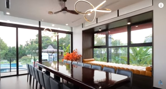 Bàn ăn lớn đủ sức chứa tới 16 người, view hồ bơi và sân golf.