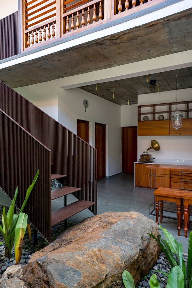 Những tảng đá tự nhiên khổng lồ được đặt trong sân với cầu thang nổi phía trên và cây xanh xung quanh để khoảng sân trở thành tâm điểm.