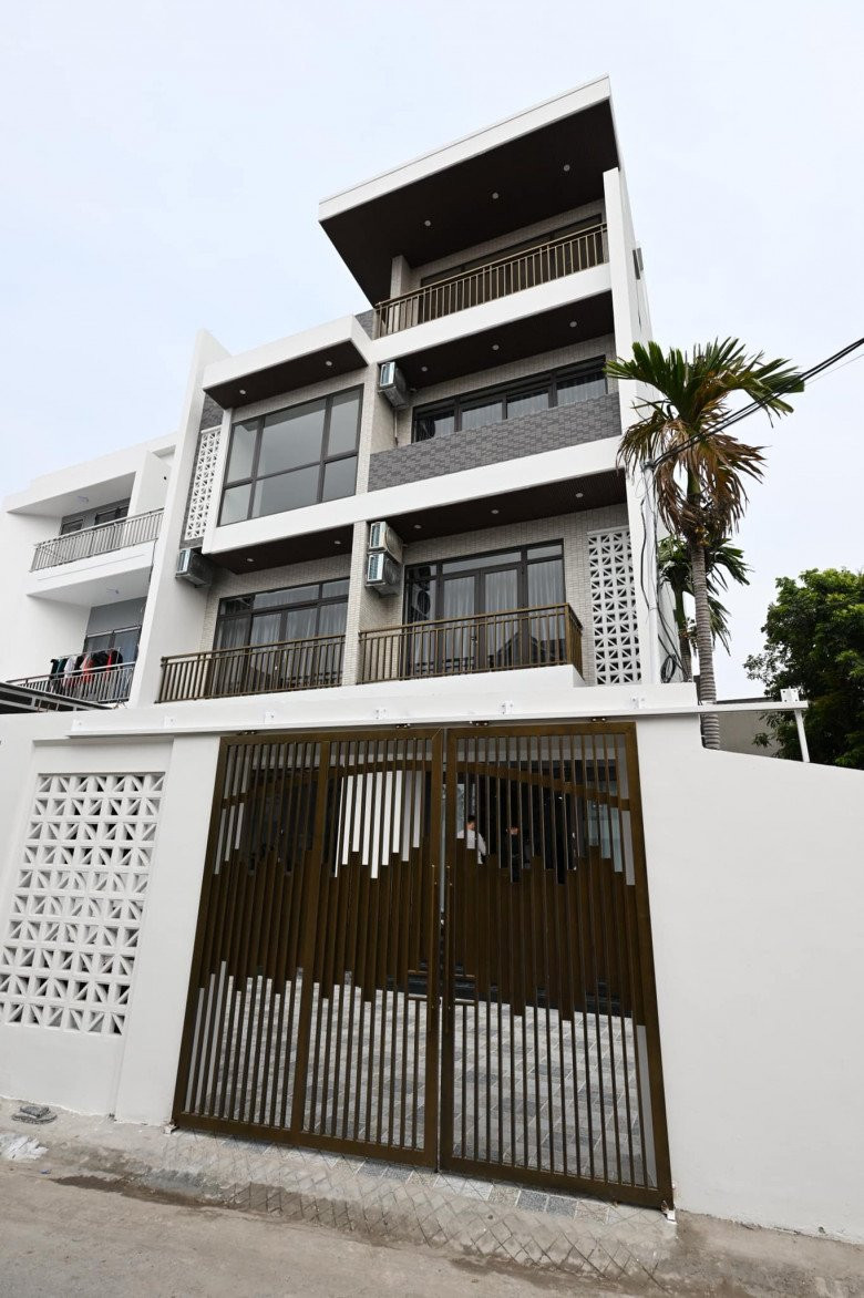 Căn nhà có gam màu trắng chủ đạo, kết hợp với màu đen và màu nâu vàng của cổng nhà.