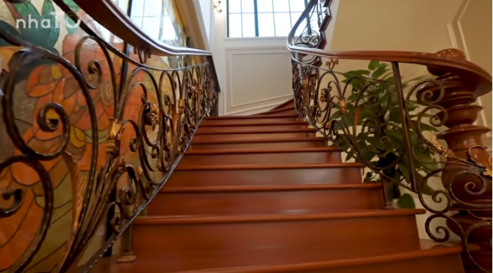 Ngoài thang máy, trong căn biệt thự còn có cầu thang bộ bằng gỗ gõ đỏ.