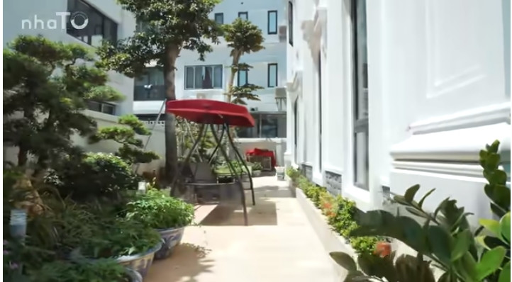 Bao quanh biệt thự là khoảng sân trồng nhiều cây cảnh và lát bằng đá tự nhiên.
