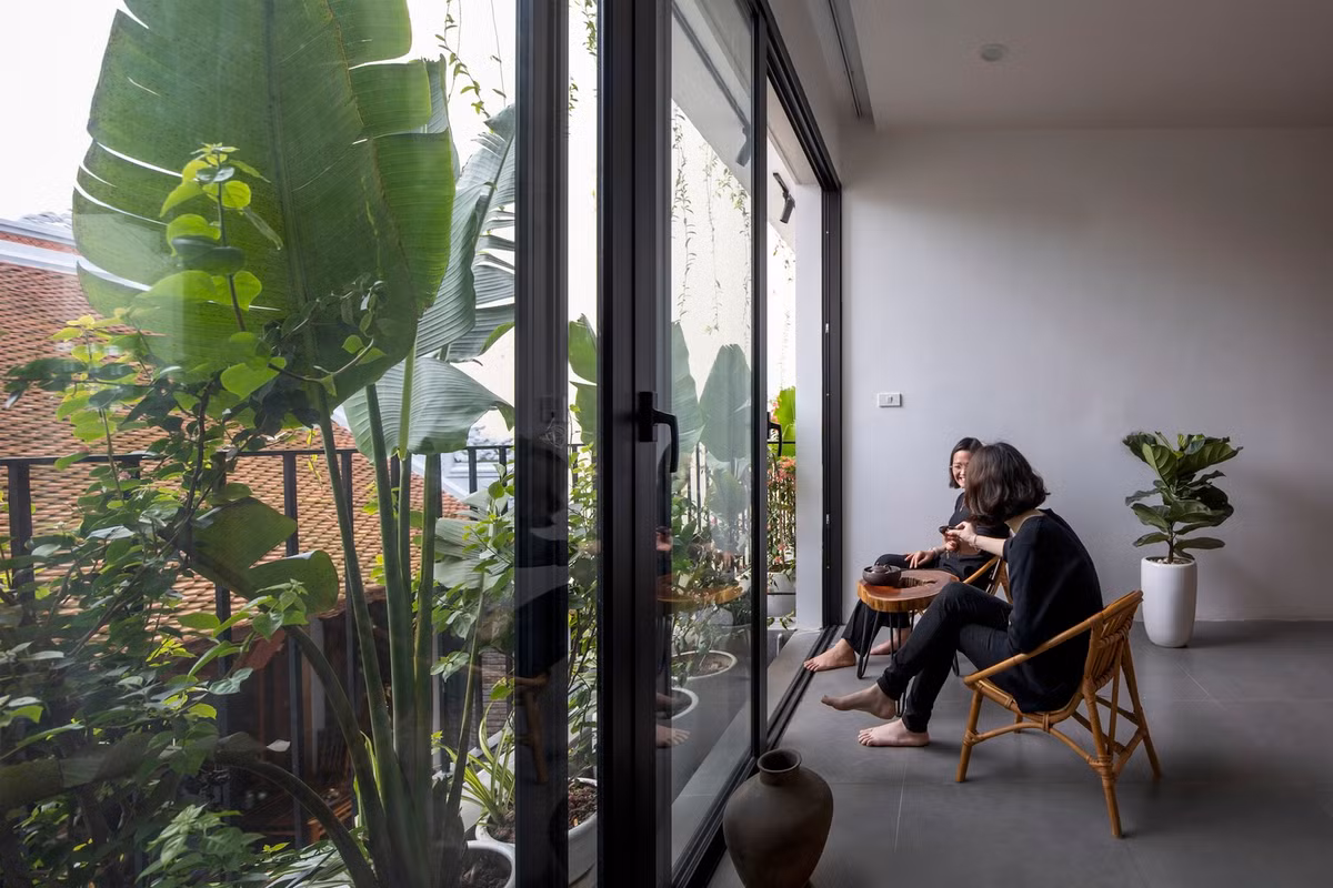 Tầng 2 được chia làm 2 không gian, kết nối với nhau bởi khoảng sân nhỏ đầy màu xanh.