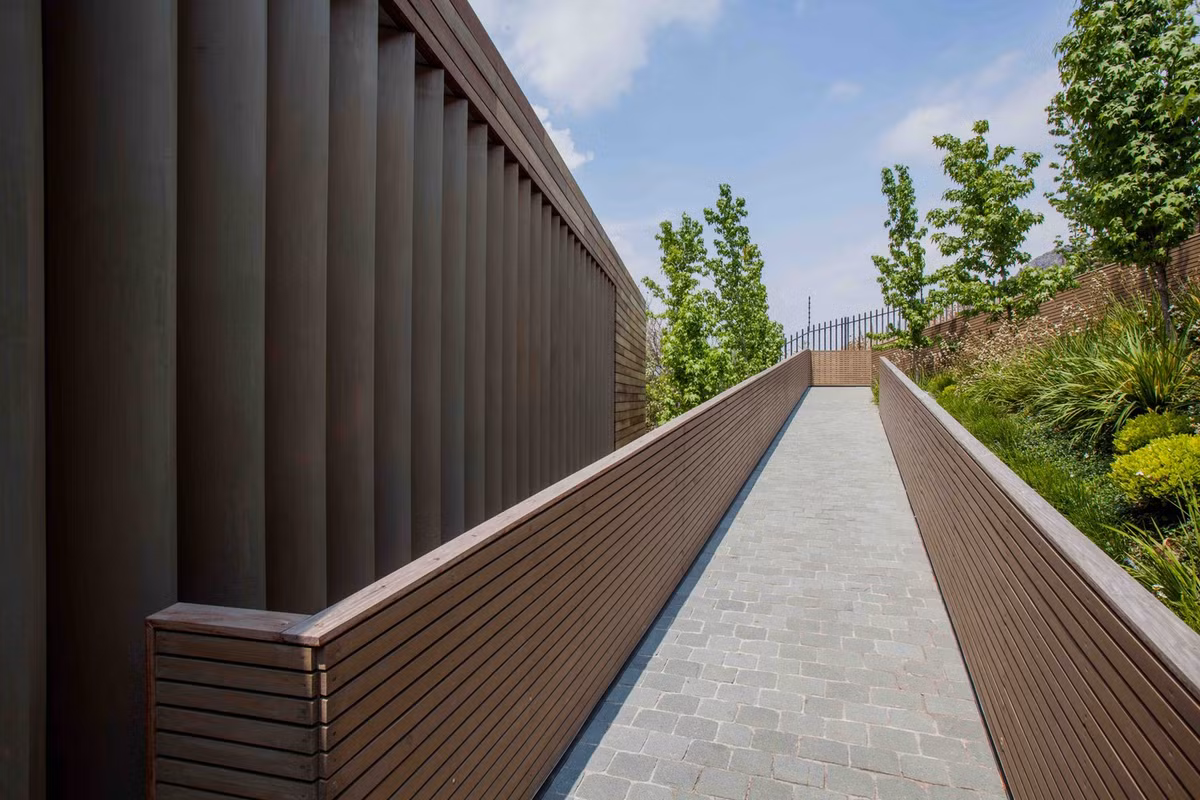 Lối vào nhà được lát gạch so le chống trơn trượt hiệu quả, 2 bên là lan can ốp gỗ sang trọng. Nguồn ảnh: Archdaily