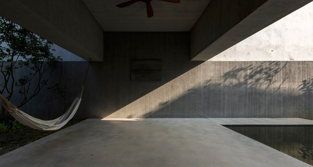 Nền bê tông đánh bóng bằng sáp trong, tường và trần nhà được cào xước trước khi sơn chống thấm gốc xi măng xám.