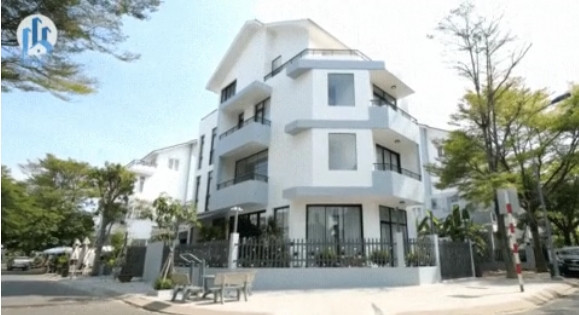 Ngôi nhà nổi bật với gam màu trắng - xám chủ đạo, bao quanh là hàng rào và cây cối. Ảnh: chụp màn hình NhaF