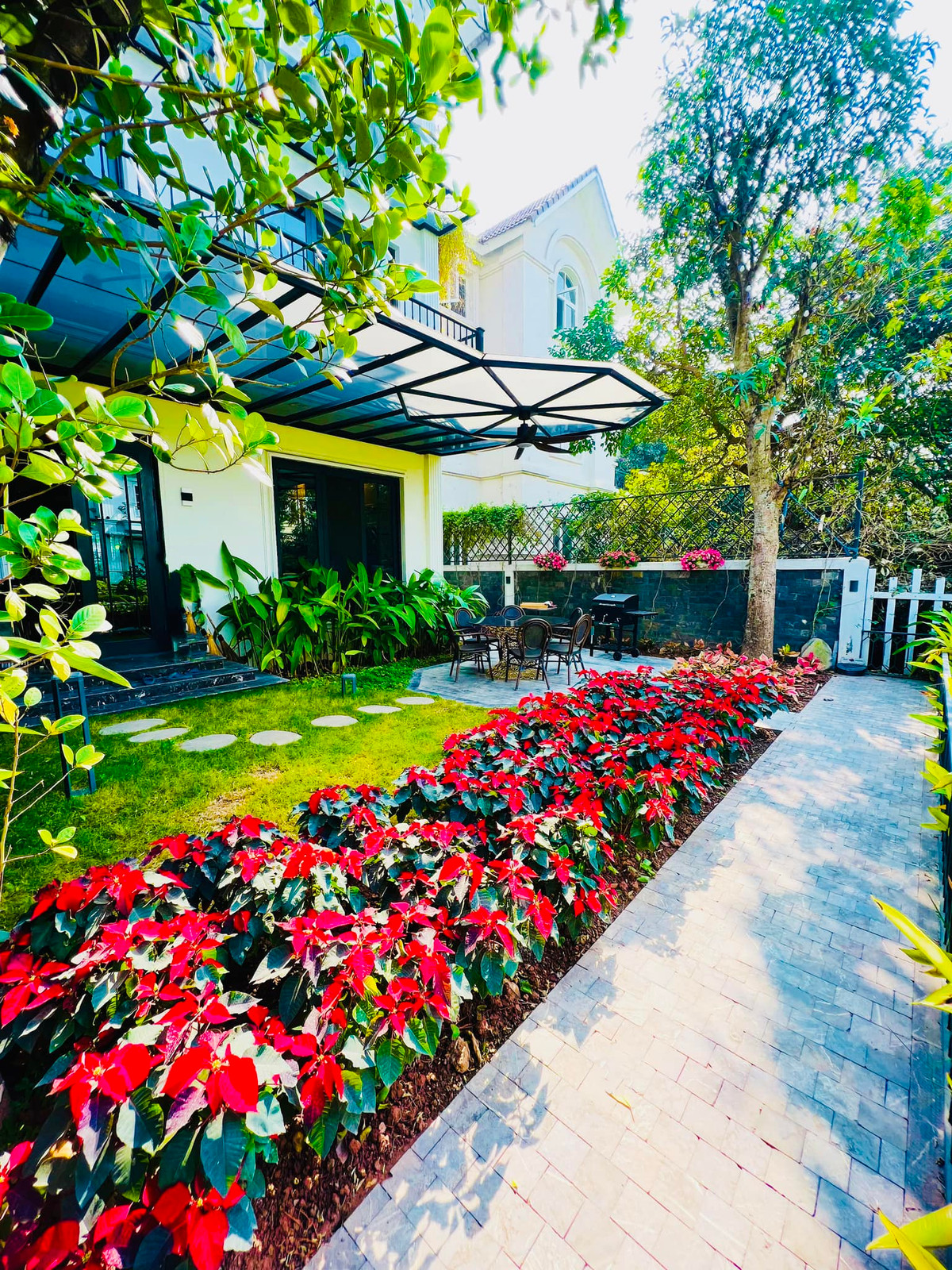 Khuôn viên sân vườn thiết kế gọn gàng, trồng nhiều cây xanh và hoa.