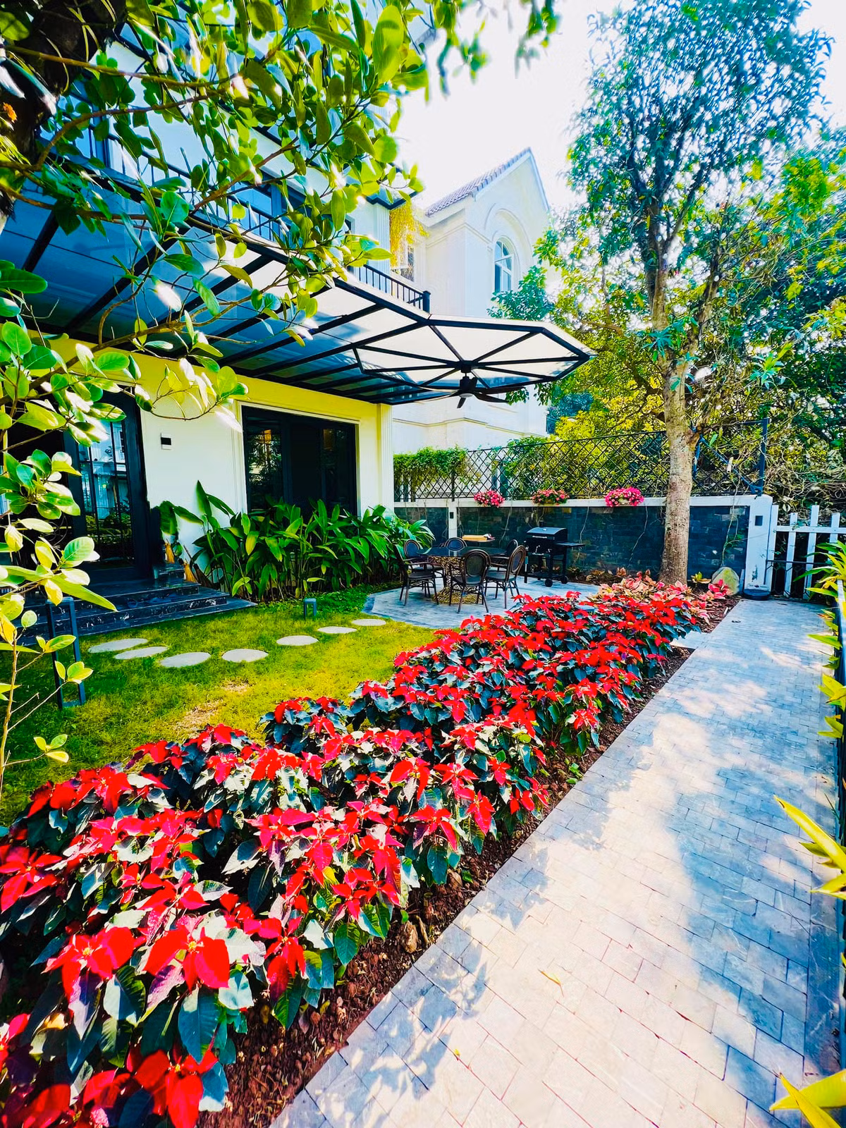 Khuôn viên sân vườn thiết kế gọn gàng, trồng nhiều cây xanh và hoa.