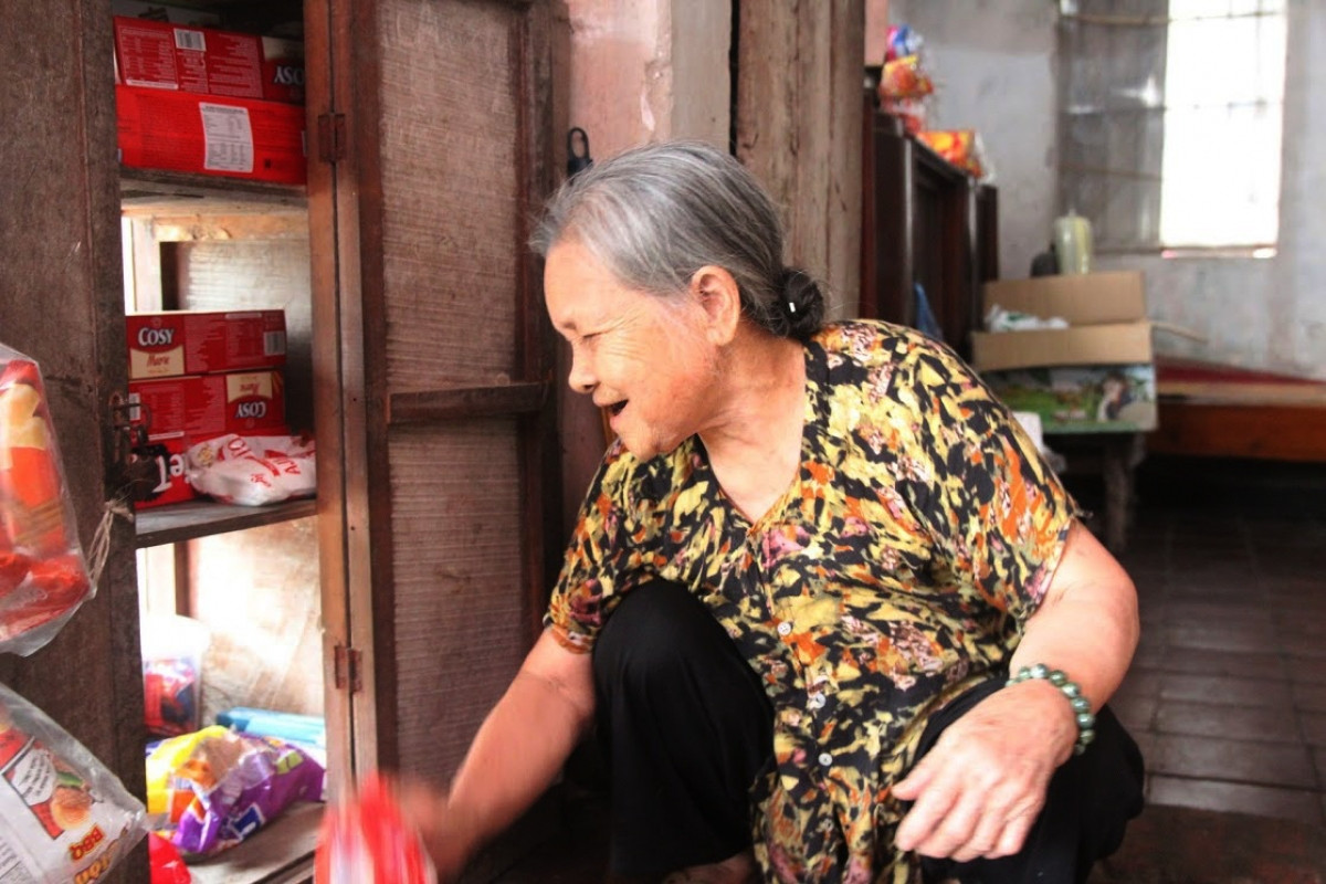 Không biển hiệu, chẳng mái che, cũng không cần tủ kính, kệ sắt hiện đại, cửa hàng tạp hoá của cụ chỉ gồm một chiếc tủ gỗ cũ nằm lọt thỏm bên trong những bức tường gạch. Ảnh: VOV