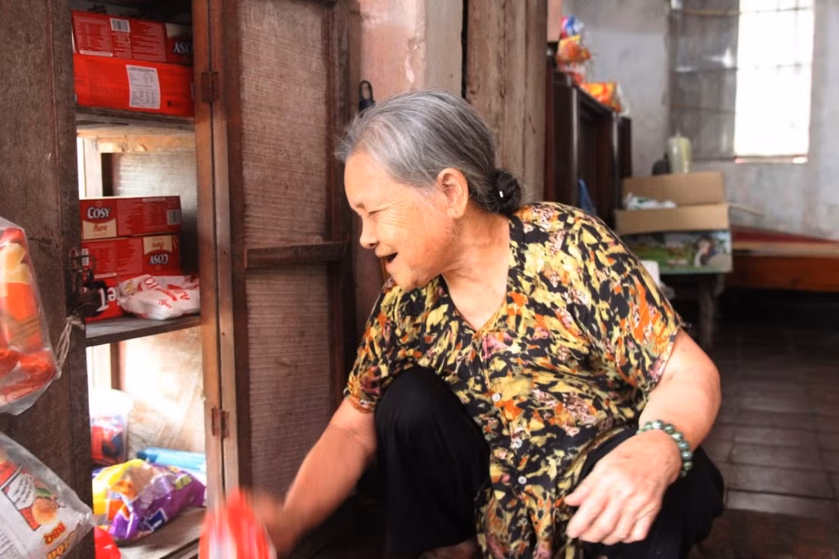 Không biển hiệu, chẳng mái che, cũng không cần tủ kính, kệ sắt hiện đại, cửa hàng tạp hoá của cụ chỉ gồm một chiếc tủ gỗ cũ nằm lọt thỏm bên trong những bức tường gạch. Ảnh: VOV