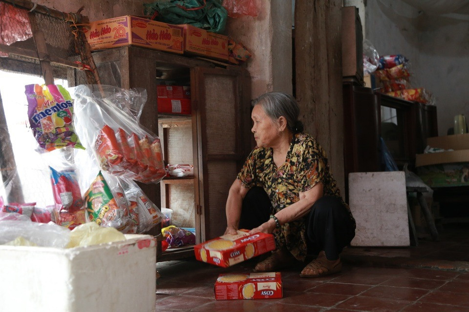 Hàng ngày, cụ Tâm tỉ mỉ sắp xếp hàng hóa, từng chiếc kẹo mút, gói bim bim... Ảnh: Dân trí