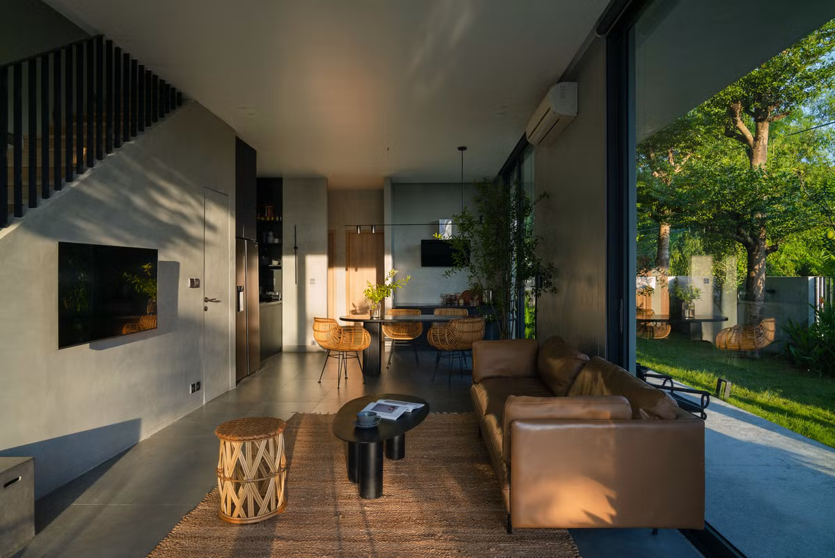 Mọi không gian bên trong nội thất đều được thiết kế để đón ánh sáng tự nhiên, kết hợp với những vật liệu đơn giản, đồng bộ nổi bật trên nền xanh của lá cây.