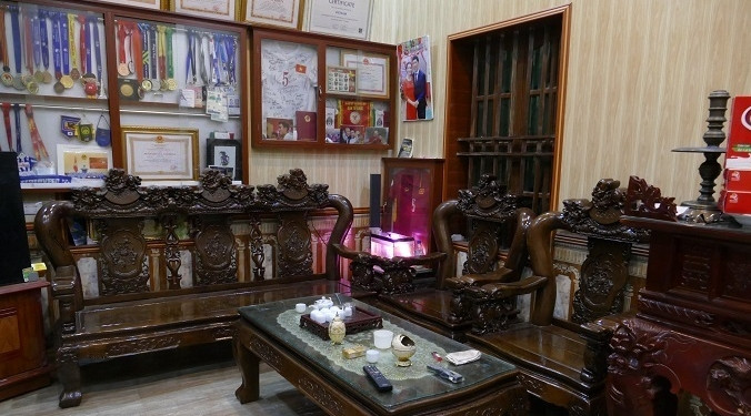 Phòng khách gọn gàng với bộ bàn ghế gỗ. Ảnh: Vietnamnet