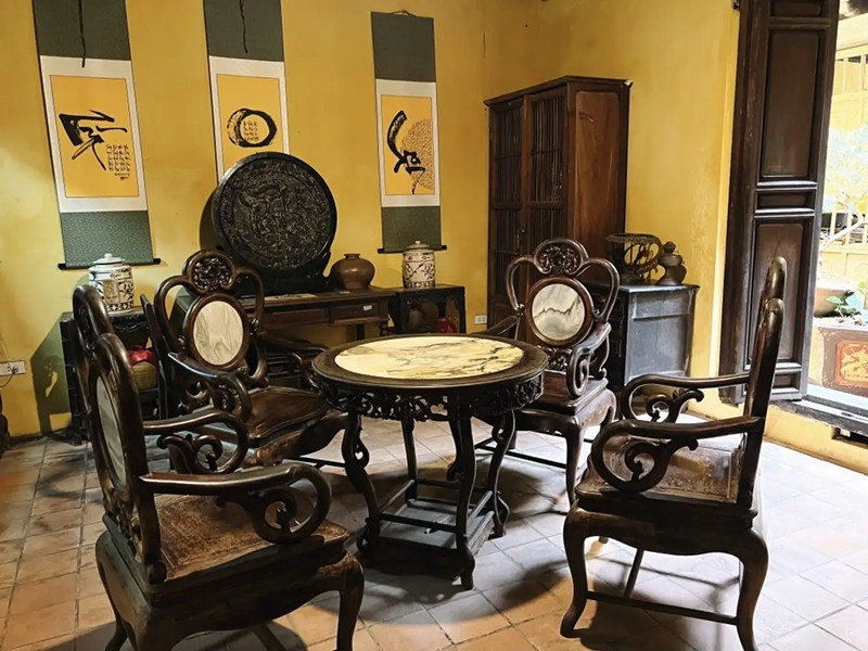 Gian nhà hậu (còn được gọi phòng khách) có một bộ bàn tròn và 4 ghế gỗ dùng cho việc ăn uống. Ảnh: Traveloka