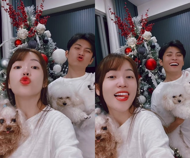 Cặp đôi thích thú chụp hình bên cây thông và cún cưng.