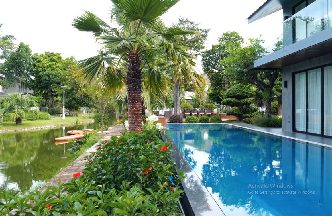 Phía sau ngôi nhà là bể bơi lớn xanh ngắt.