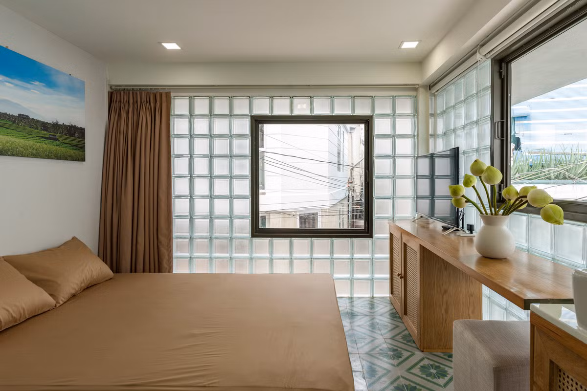 Tầng đầu tiên có một dãy phòng ngủ nhỏ gọn với phòng tắm và tủ quần áo được giấu liền mạch sau những vách ngăn bằng kính.