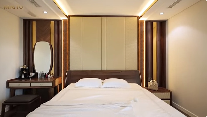 Tầng 2 gồm 3 phòng ngủ. Trong đó, phòng ngủ master sử dụng tông màu kem chủ đạo với nội thất gỗ óc chó kết hợp da.