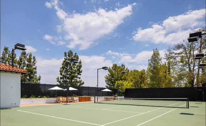 Không gian thư giãn ngoài trời với sân tennis, hồ bơi, và khu vực nấu nướng, ăn uống.