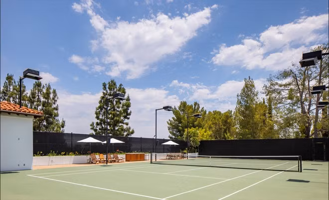 Không gian thư giãn ngoài trời với sân tennis, hồ bơi, và khu vực nấu nướng, ăn uống.