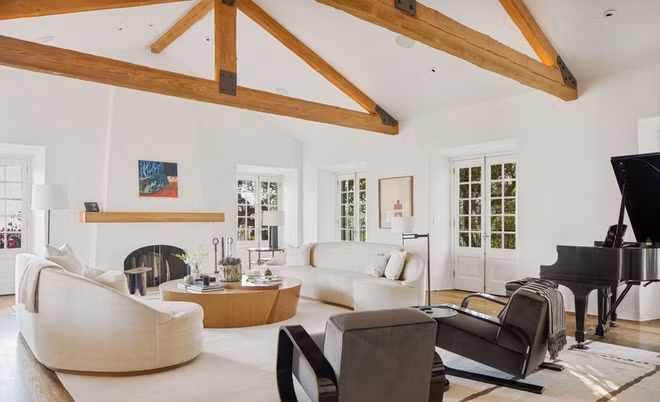 Phòng khách mang phong cách cổ điển với điểm nhấn là lò sưởi và chiếc piano.