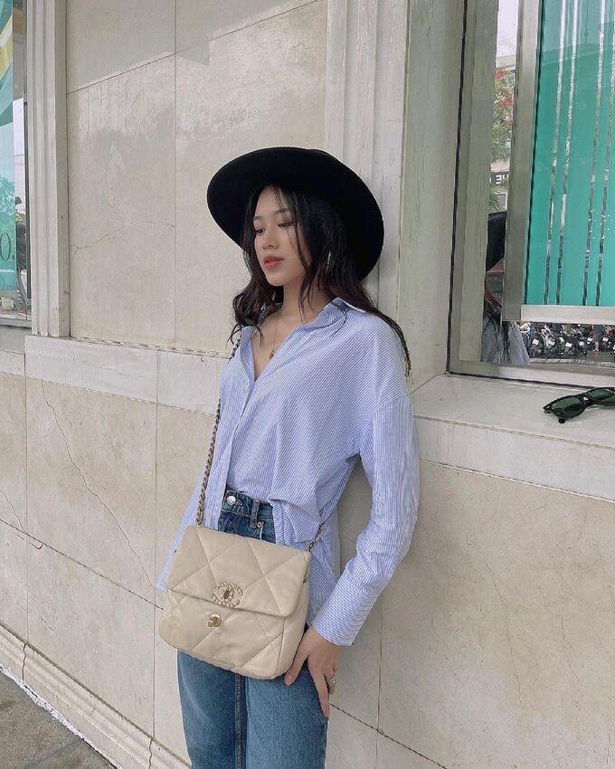 Trước đó, trong một bộ hình, Đỗ Thị Hà diện sơ mi kẻ sọc cùng quần jeans khá đơn giản. Cô khoe chiếc túi Chanel 19 có giá "khủng", khoảng hơn 100 triệu đồng. Tuy nhiên chính chiếc túi xách này lại gây chú ý nhất, không phải vì giá cả mà vì nàng hậu không thèm... đóng lại cho gọn gàng. Chưa kể, chiếc mũ màu đen cũng hoàn toàn "lạc quẻ" với tổng thể.