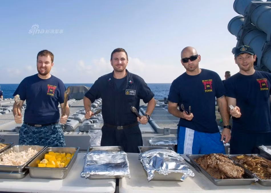 Các đầu bếp bày bàn tiệc bên cạnh hệ thống giếng phóng 42 ống của khu trục hạm DDG-56. Nguồn ảnh: Sina.