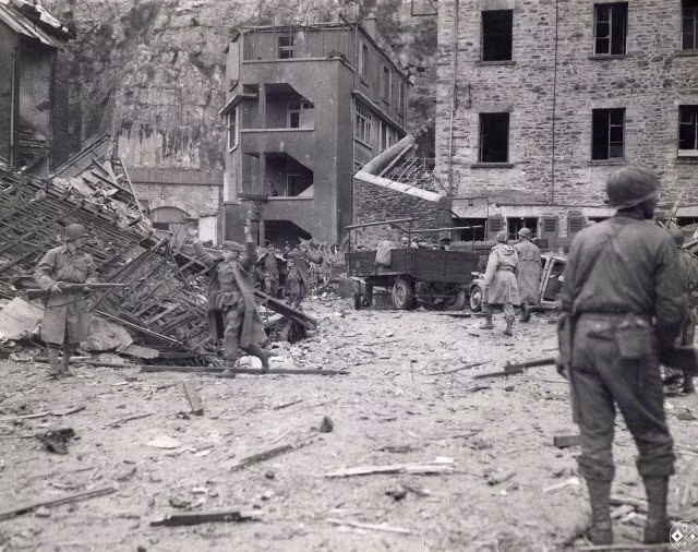 Quân Đức ra đầu hàng Đồng Minh, phía sau lưng họ là một bãi chiến trường hoang tàn và đổ nát. Nguồn ảnh: Warhistory.