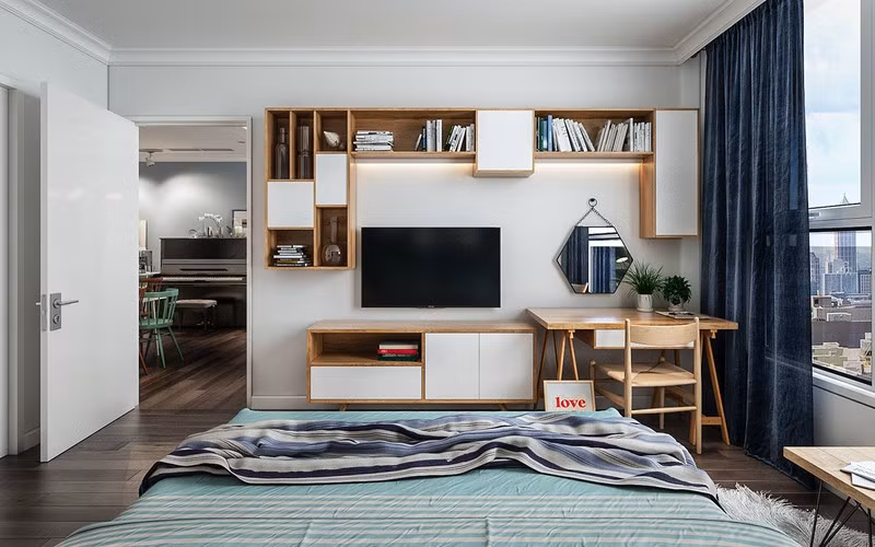 Kệ tivi, bàn làm việc và giá sách đặt ở cuối giường, nhằm phục vụ nhu cầu hàng ngày của chủ nhà.