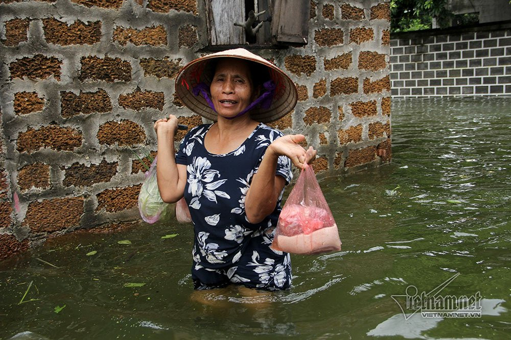 Bà Nguyễn Thị Phiến (58 tuổi) phải lội nước 2km ra đầu xã để nhận đồ tiếp tề từ con cái