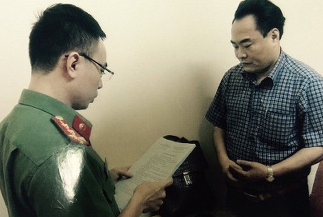 Đối tượng Trần Đức Trung nghe đọc lệnh bắt. Nguồn ảnh: ANTĐ