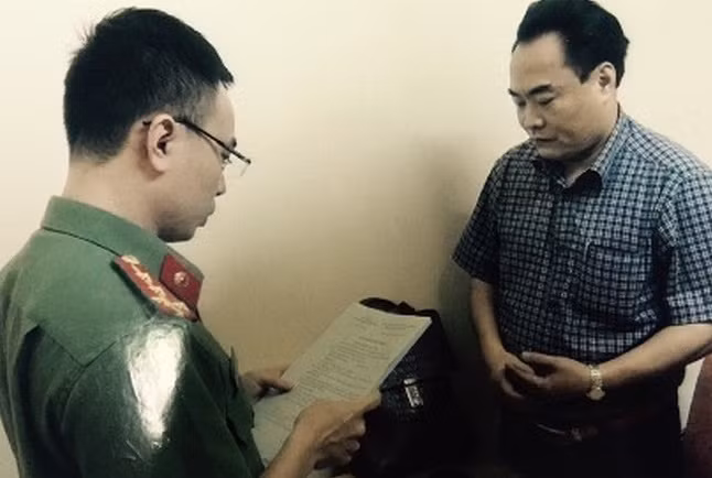 Đối tượng Trần Đức Trung nghe đọc lệnh bắt. Nguồn ảnh: ANTĐ