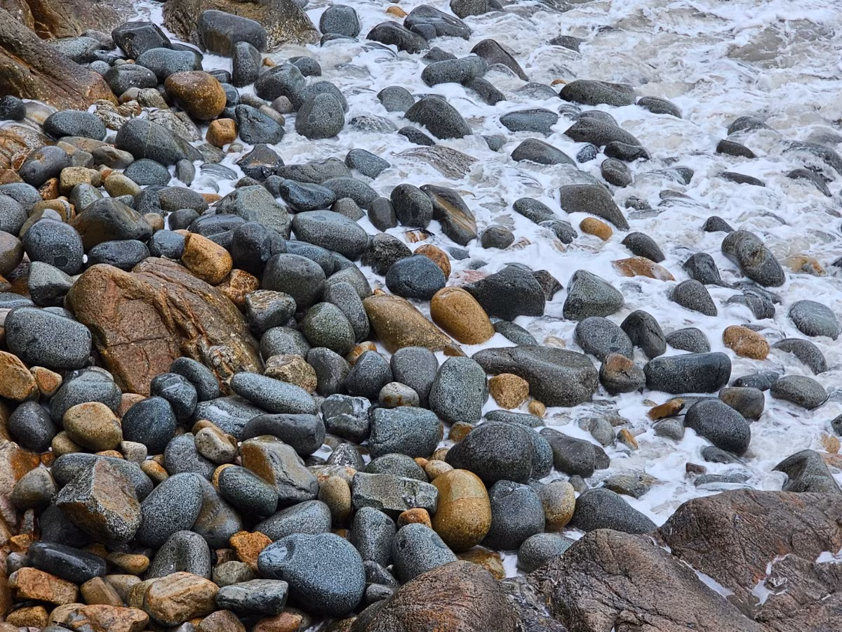 Bãi đá rộng hàng trăm mét vuông với những hòn đá tròn nhẵn nhụi do sóng biển vỗ bờ bào mòn theo năm tháng...