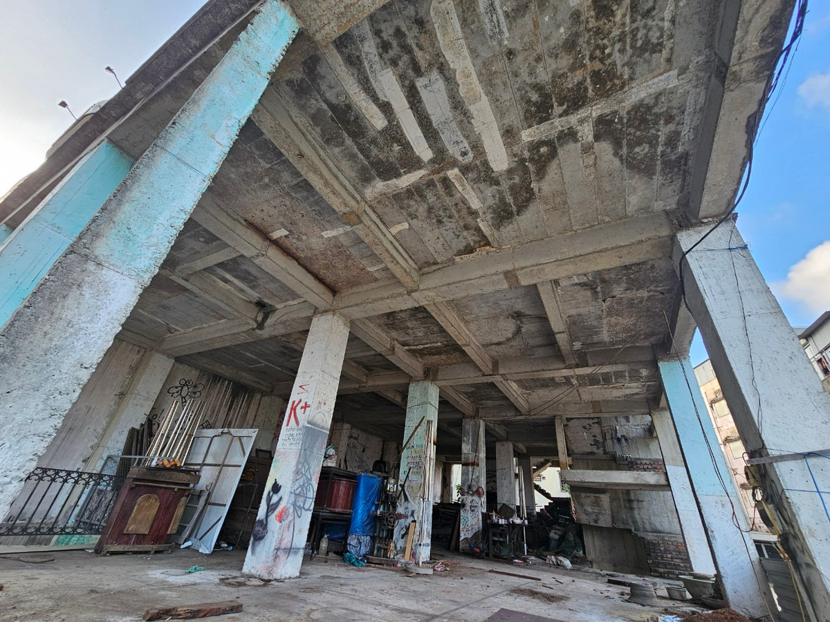 Tầng 1 của công trình bỏ hoang trở thành kho lộ thiên với ngổn ngang các đồ dùng, vật dụng cũ nát.