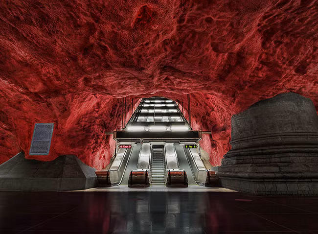 Ga Solna, Stockholm, Thụy Điển: Thiết kế nổi bật của ga Solna tạo cảm giác cho mọi người như bước vào một hang động đá đỏ. Tạo hình đầy phong cách nghệ thuật này nhằm phản ánh lại các vấn đề đang gây nhức nhối toàn xã hội như suy thoái nông thôn và phá rừng.