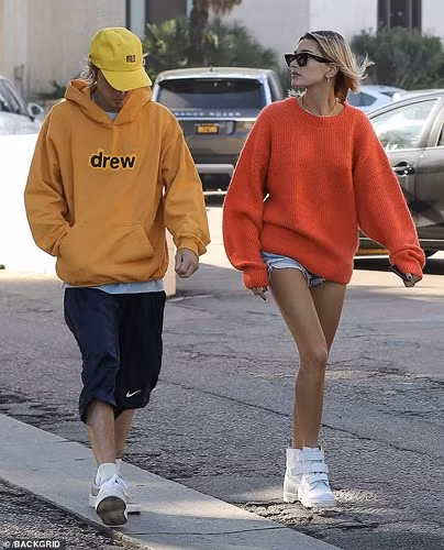 Trong khi đó, vị hôn thê của anh lại khoe đôi chân thon dài miên man với quần shorts denim cá tính và áo len cam dáng rộng.