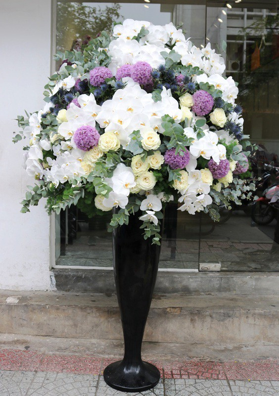 Một bình hoa khác có giá 70 triệu đồng cũng khiến người mua phải chú ý. Bình hoa này gồm có hoa hồng trắng nhập khẩu giá 120.000 đồng/cành, lan hồ điệp 350.000 đồng/cành, hoa sao Hà Lan 180.000 đồng/cành và một số lá nhập nhuộm màu vàng, màu bạc. (Ảnh: Dân trí).