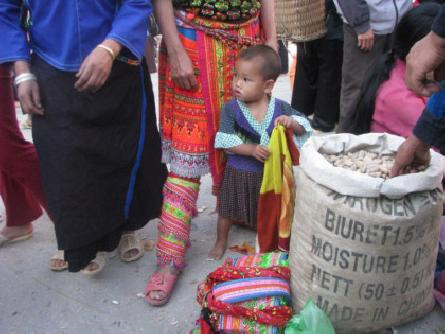 Ngay từ khi còn nhỏ, các em bé dân tộc đã biết cách giúp đỡ bố mẹ bán hàng. Ảnh: Dulich.