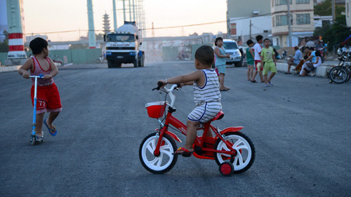 Em nhỏ đi xe đạp trước đầu xe tải. Các bậc phụ huynh có suy nghĩ gì khi nhìn cảnh tượng này? Trẻ em rất hiếu động và luôn làm theo sở thích của mình, vì vậy, cha mẹ cần tạo cho con không gian chơi an toàn, trong lành hoặc chơi cùng con để trẻ được phát triển hoàn thiện nhất. Ảnh: Songkhoe.