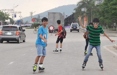 Việc chơi đùa dưới lòng đường ngay trước mũi xe hơi như thể là một điều quá bình thường đối với các em và với cả những người lớn xung quanh ở đô thị. Ảnh: Duongbo.