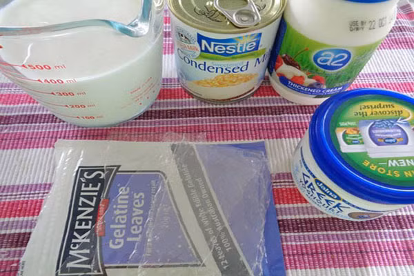 Đầu tiên, hãy chuẩn bị đầy đủ nguyên liệu: sữa tươi, sữa chua cái, sữa bột mi lô, rau câu, hộp đựng sữa chua, lá glatin, nước sôi. Ảnh: Congthucmonngon.