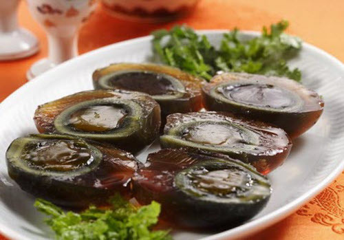 Trứng thế kỷ, Trung Quốc. Loại trứng có mùi vị lạ lùng này được người dân Trung Quốc chọn để bắt đầu ngày mới. Trứng thế kỷ được ngâm trong hỗn hợp đất sét, muối, tro, vôi và gạo. Sau một thời gian, lòng đỏ trứng sẽ chuyển sang màu xanh, lòng trắng trứng hóa màu đen lẫn mùi hăng khó chịu. Ảnh: vatc
