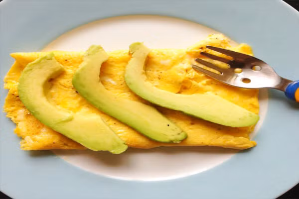  Tráng trứng cùng bơ và phô mai tươi. Món ăn này sẽ khiến ngay cả những đứa trẻ khó tính nhất cũng phải mê. Món ăn này ngon chính bởi sự đơn giản trong cách chế biến. Phô mai quyện với trứng thơm lừng, ăn kèm những miếng bơ thái lát mỏng xếp đều trên bề mặt trứng. Chỉ cần nghĩ tới thôi đã thấy hấp dẫn rồi. 