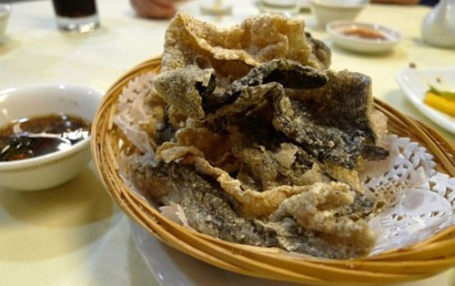 Da cá chiên giòn. Món ăn vặt này có xuất xứ ở Nhật Bản, trước khi người Hồng Kông tạo ra phiên bản của riêng họ. Món này giòn tan, thơm mùi cá, vị đậm đà vừa phải và không quá ngấy. Da cá chiên giòn có thể ăn kèm với cháo hoặc mỳ.