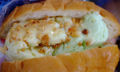 Bánh mỳ kem là sự kết hợp giữa bánh mì và kem tươi hấp dẫn ở Sài Gòn. Bánh mì được rạch giữa rồi cho vào 2 - 3 muỗng to kem có vị dừa, vani, khoai môn hoặc tổng hợp theo yêu cầu. Mỗi chiếc bánh mỳ kem có giá từ 6.000 - 8.000 đồng. Ảnh: xinhxinh