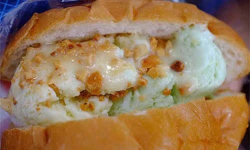Bánh mỳ kem là sự kết hợp giữa bánh mì và kem tươi hấp dẫn ở Sài Gòn. Bánh mì được rạch giữa rồi cho vào 2 - 3 muỗng to kem có vị dừa, vani, khoai môn hoặc tổng hợp theo yêu cầu. Mỗi chiếc bánh mỳ kem có giá từ 6.000 - 8.000 đồng. Ảnh: xinhxinh