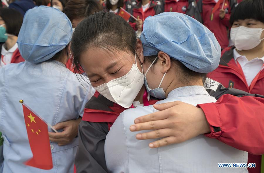 Gui Xin (phải) từ Bệnh viện số 1 Vũ Hán ôm Wang Bokun, một nhân viên y tế từ Thiên Tân, khi Wang rời khỏi Vũ Hán, thủ phủ của tỉnh Hồ Bắc ngày 21/3 sau khi hoàn thành nhiệm vụ.