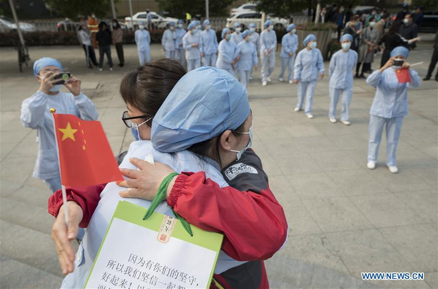 Một y tá (phía trước) của Bệnh viện số 1 Vũ Hán ôm Li Mei, một nhân viên y tế từ Thiên Tân khi Li rời Vũ Hán ngày 21/3.