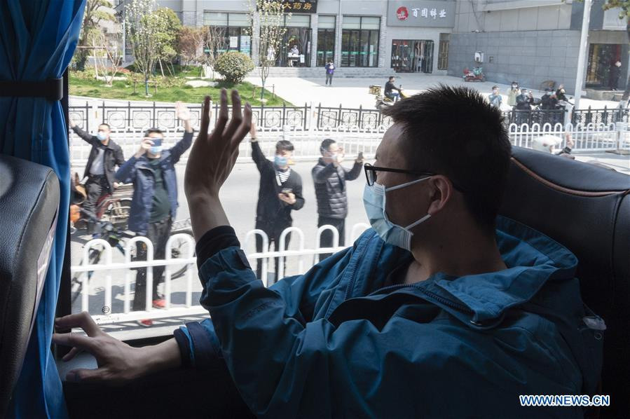 Một nhân viên y tế vẫy tay tạm biệt cư dân địa phương trước khi rời đi ở thành phố Tương Dương.