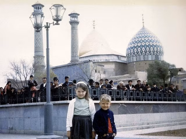 Hai em bé người Mỹ ở Isfahan năm 1963. Đằng sau, có nhiều người cũng đang hướng ánh nhìn về phía các em.